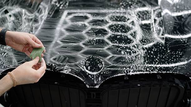 istock Car detailer preparing microfiber cloth for cleaning soapy black car hood 2229793043