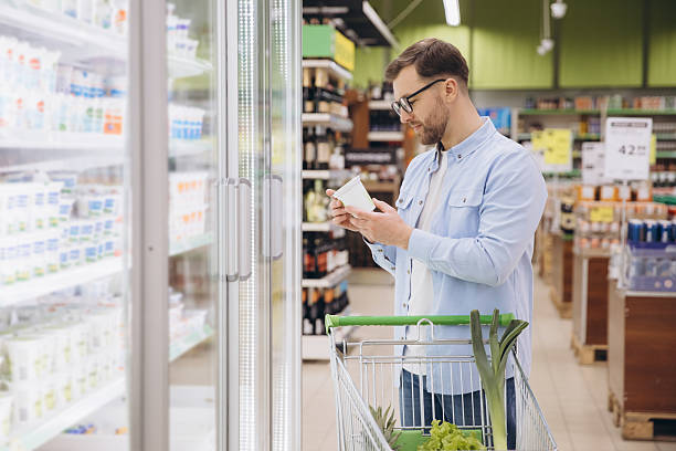 istock Customer Reading Product Label in Supermarket Refrigerator Section 2229793722