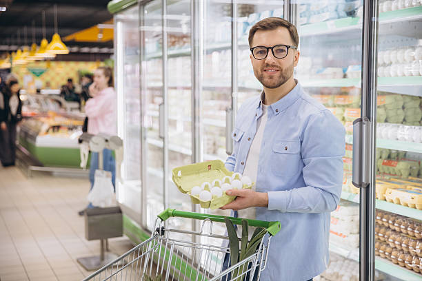 istock Customer choosing eggs in refrigerated section of supermarket 2229793743