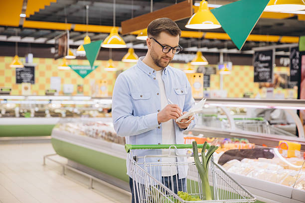 istock Man writing grocery list while shopping in supermarket 2229793785