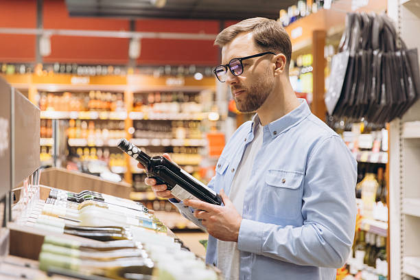 istock Customer Choosing Wine Bottle in Supermarket Drinks Section 2229793821