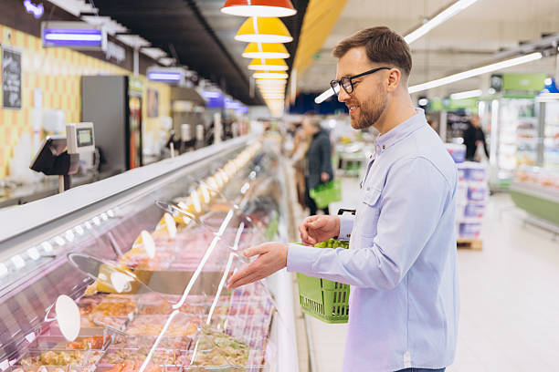 istock Man Choosing Fresh Meat in Refrigerated Display at Supermarket 2229793857