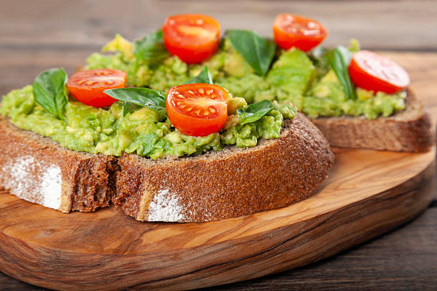 istock Healthy avocado sandwich, toast bread. Mushed avocado paste, on wooden background. 2229796734