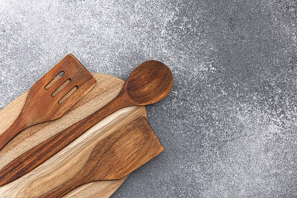 istock Wooden kitchen utensils arranged on a textured gray background for cooking and serving 2229799878