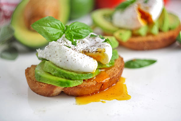 istock Sliced avocado and poached egg on toasted bread 2229800645