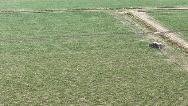 istock Capturing the Vast Expansive Green Agricultural Fields from Above as a Lone Farmer Engages in Essential Field Spraying Operations for Crop Protection and Growth 2229809524