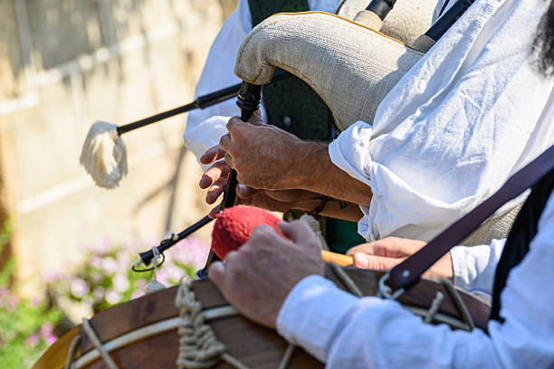 Pipers wearing traditional clothing, playing as they walk in a folk street band in a traditional festival, San Froilán in Lugo, Galicia, Spain.