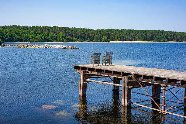 istock Serene lakeside pier with chairs 2229812768