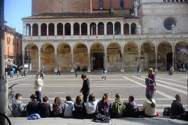 Cremona, Italy March 15th 2025 Group of students sitting in Piazza Duomo, enjoying their school trip in Cremona, Lombardy, with the Loggia delle Benedizioni and Torrazzo in view