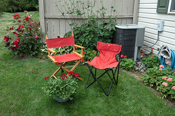 Relaxing flower garden area with two red chairs.