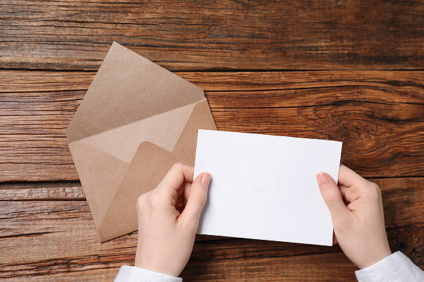 istock Woman with blank card at wooden table, top view. Space for text 2229823741