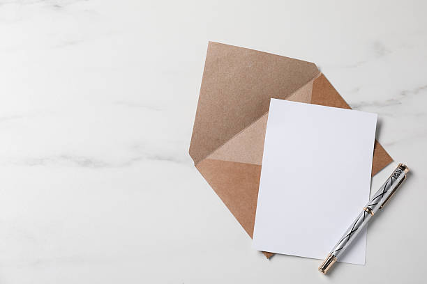 istock Blank sheet of paper, pen and letter envelope on white marble table, top view. Space for text 2229823754