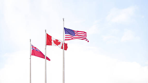 istock Three flags waving in the breeze against a bright sky, symbolizing unity and diversity among nations with a peaceful atmosphere 2229824217