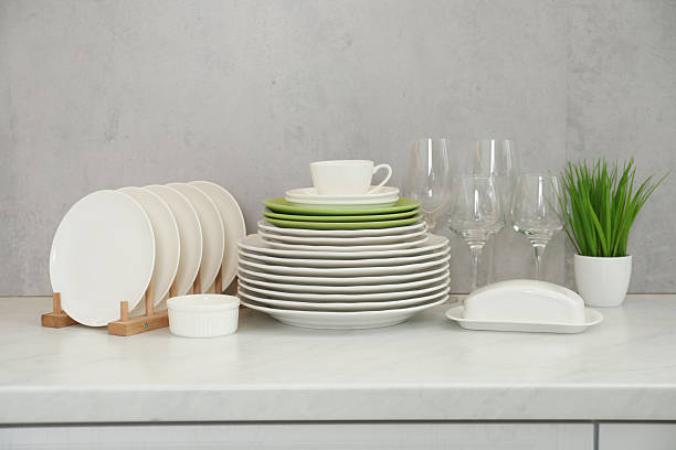 istock Clean plates, glasses, cup and floral decor on white marble table 2229825045