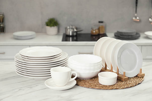 istock Clean plates, bowls and cup on white marble table in kitchen 2229825072