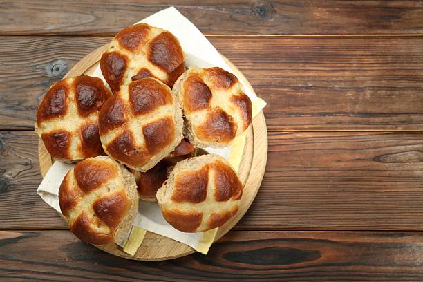 istock Tasty hot cross buns on wooden table, top view. Space for text 2229826599