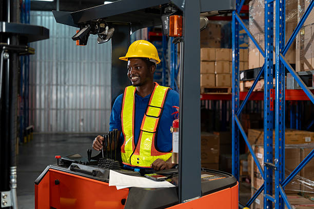 istock Smiling warehouse worker operating forklift in distribution center, focusing on transportation, inventory handling, and workplace efficiency in industrial logistics. 2229829911