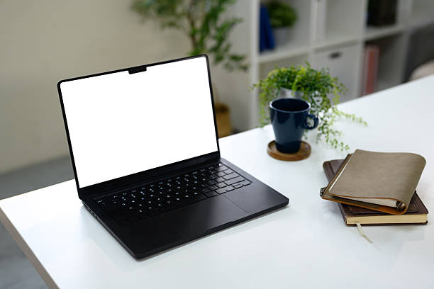 istock Minimalist workspace with black screen laptop, notebooks, a coffee mug, and green plants 2229838863