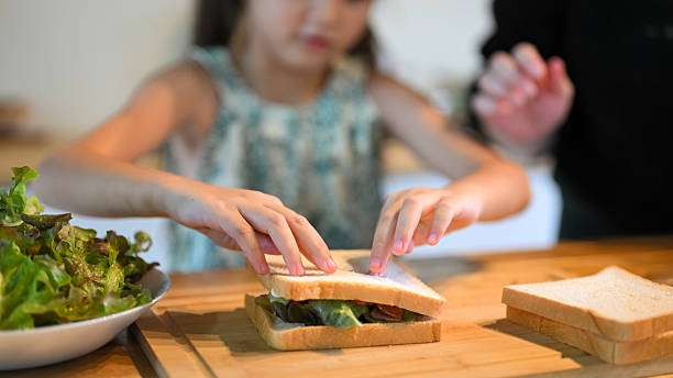 istock Child hands carefully assembling a homemade sandwich during breakfast prep 2229838956