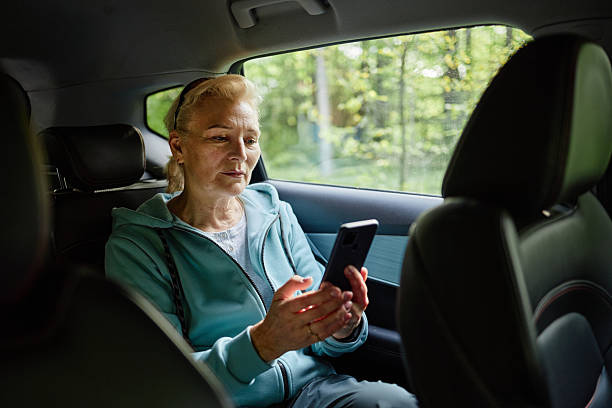 istock Senior Caucasian Woman Sitting in Car Using Smartphone for Communication 2229847099