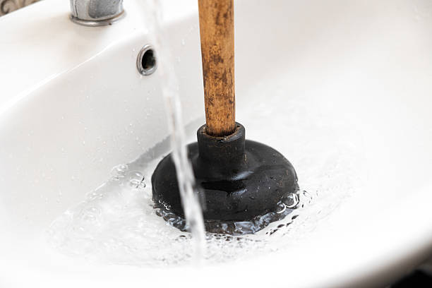 The plunger clears the clogged sink drain. Blockage in the sink. Water does not drain from the sink of the washbasin.