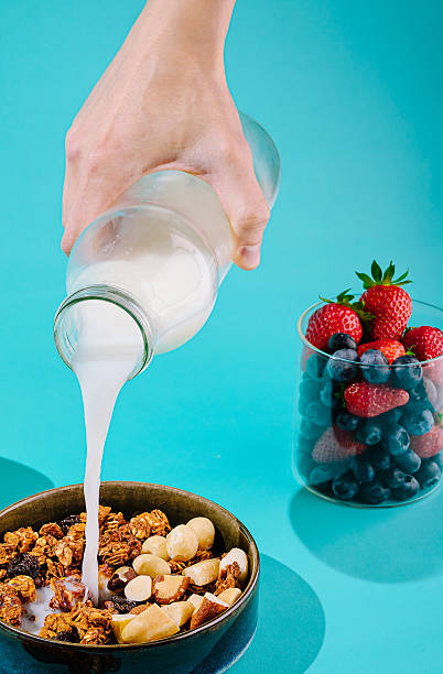 istock Pouring milk over granola with fresh berries in a vibrant kitchen setting 2229853093