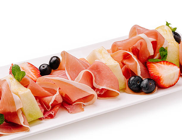 istock Delicious platter featuring prosciutto, fruit, and fresh herbs served elegantly 2229853107