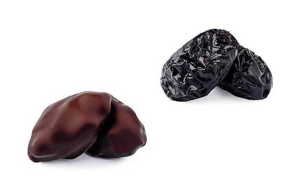 istock Delicious dark chocolate-covered dates and dried plums on white background 2229854376