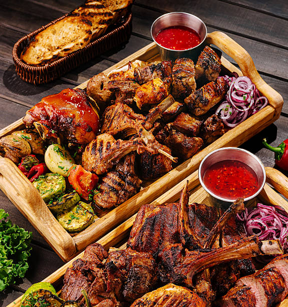istock Delicious assorted grilled meats served on a wooden platter at sunset 2229854687