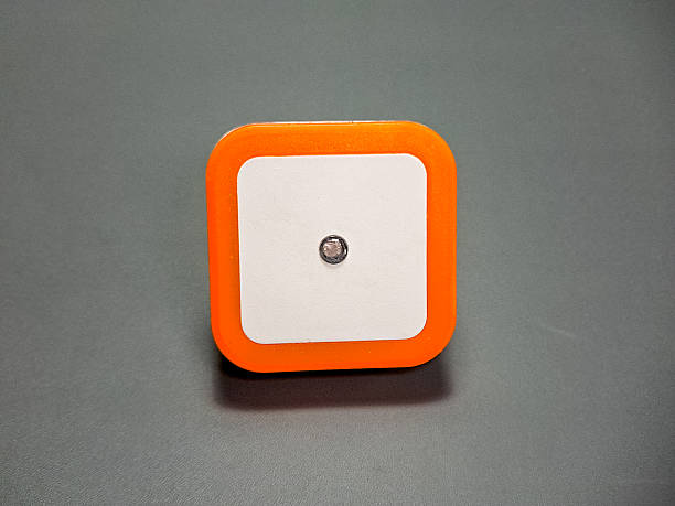 A geometric object with a rounded square form showcases modern simplicity on a neutral background, highlighting the interplay of white, orange, and a dark grey backdrop.