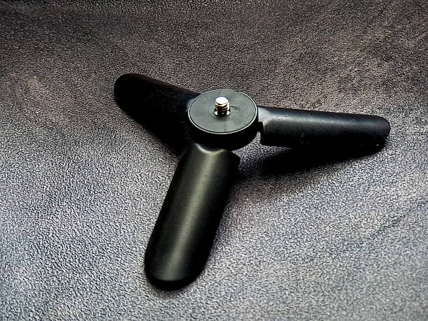 istock A sleek black mini tripod sits poised on a textured charcoal surface, embodying stability and utility with its streamlined design and geometric form, hinting readiness. 2229858322