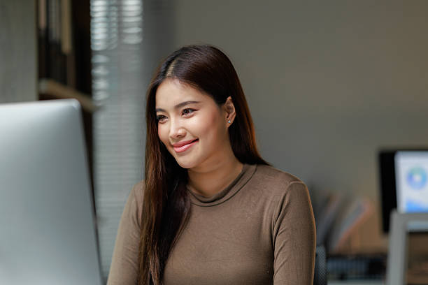 istock Young asian businesswoman smiling and working on computer in modern office 2229863451