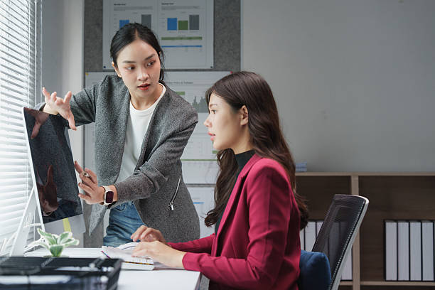 istock Businesswomen collaborating on a project at computer in office 2229866454