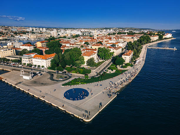 A stunning aerial view of the historic Zadar old town in Croatia, showcasing the vibrant waterfront promenade, beautiful blue waters, and iconic architecture.