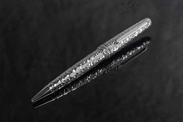 elegant black metal fountain pen with gold details on wooden background high angle view