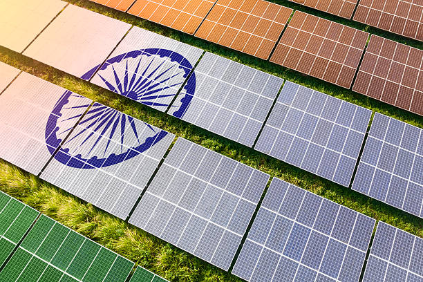Solar farm superimposed with flag of India. Symbolizing solar power and panel demand, renewable energy industry, government policy, and sustainability initiatives in the country.