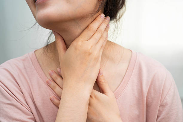 istock Asian woman touching her neck and throat for thyroid gland problem. 2229870159
