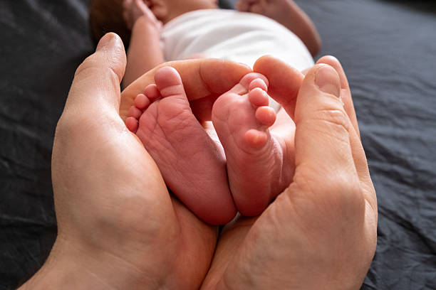 istock Tender Moment: Holding Newborn Baby Feet 2229873074