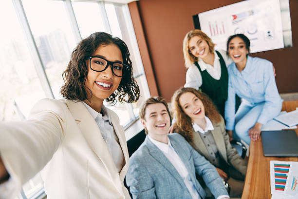 istock Work colleagues taking a cheerful team selfie in a modern office during a collaborative business meeting 2229875272