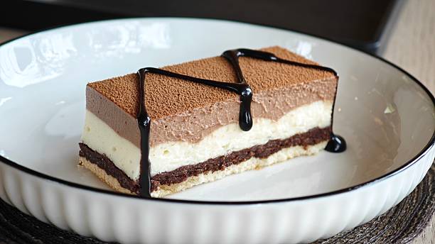 istock Three chocolates cake with chocolate drips. Layered cake with milk, dark and white chocolate souffle. 2229876413