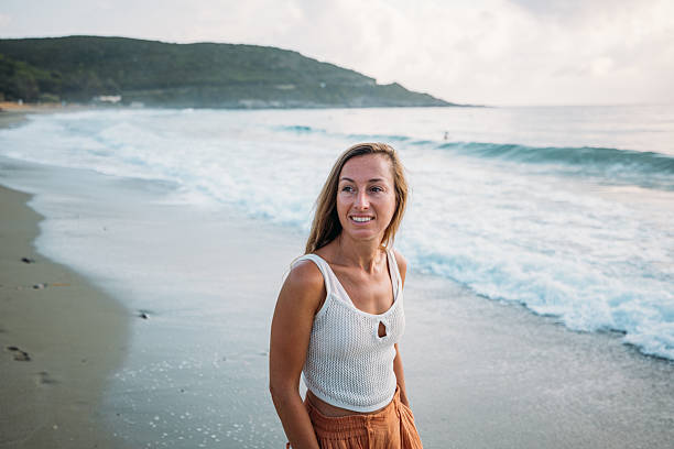 istock Woman Smiling on Beach at Sunset 2229878996