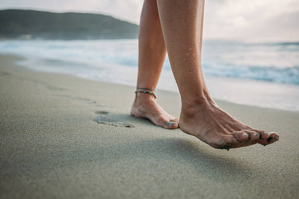 istock Bare Feet Walking on Sandy Beach Shoreline 2229879023