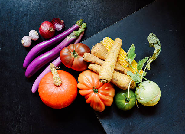 Autumn unveils a vibrant display of forgotten vegetables including heirloom tomatoes, parsnips, and soy beans. The moody lighting highlights their rich colors and textures - autumn, Halloween