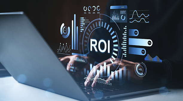 istock Businessman typing on laptop with ROI analytics dashboard and futuristic graphs concept on dark background with blue glowing interface elements. 2229882039