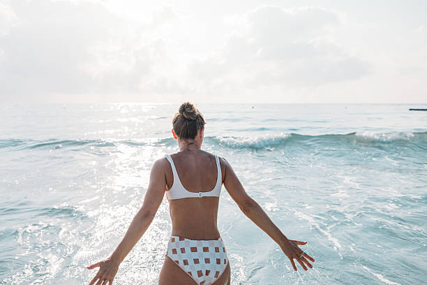 istock Woman Walking Into Calm Ocean Water 2229887375