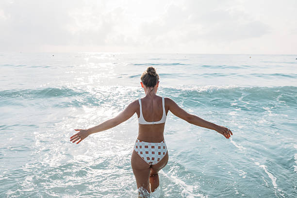 istock Woman Walking Into Calm Ocean Water 2229887390