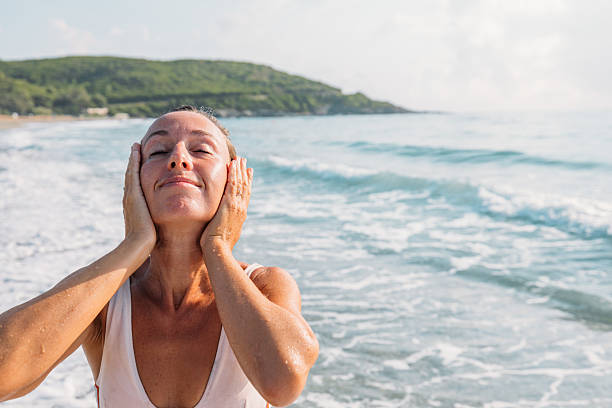 istock Smiling woman feeling refreshed after bathing in the sea 2229887525