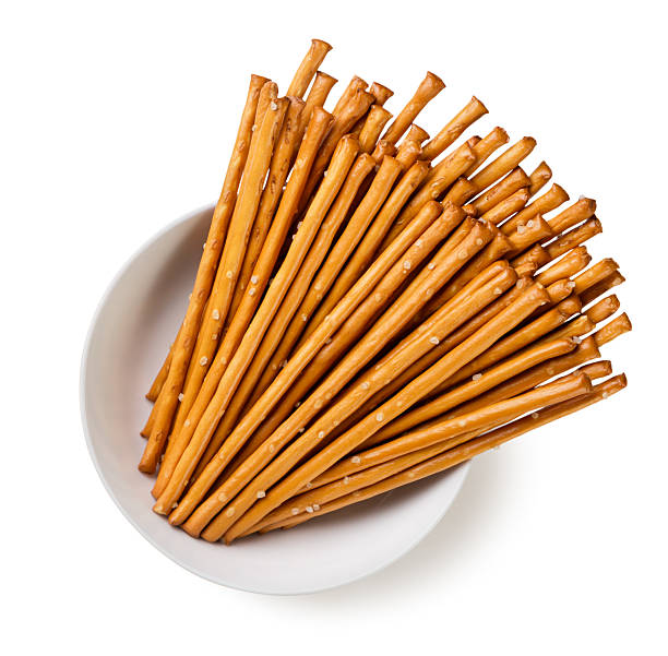 Salty cracker sticks in a plate on a white background. Top view