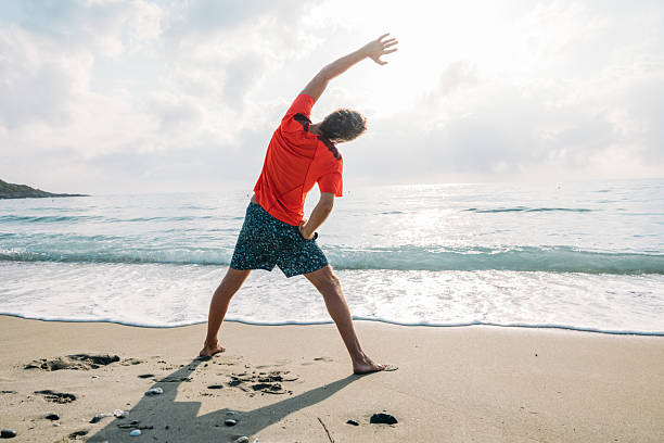 istock Man Stretching on Sandy Beach at Sunrise 2229887760