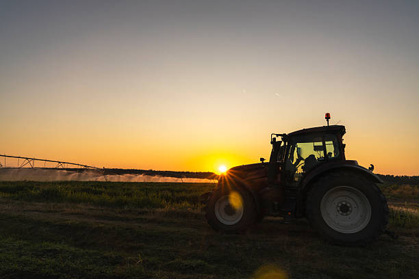 istock Tractor and agricultural watering pivot irrigation system on a corn field 2229888362